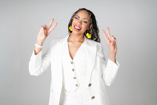 Smiling model in white blazer winking and showing victory sign