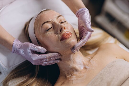 Cosmetologist applying facial skincare treatment at spa salon