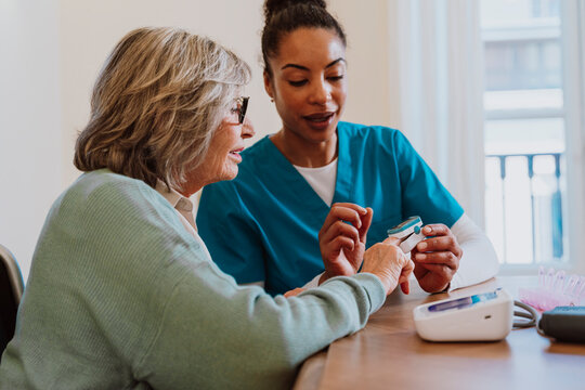 Nurse monitoring oxygen saturation with pulse oximeter during checkup