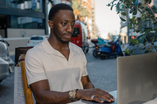 Freelancer working remotely on laptop at outdoor cafe