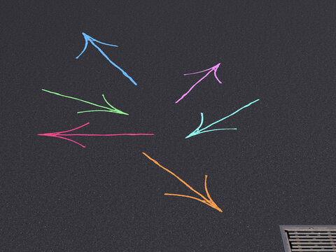 Colorful arrows pointing in different directions on dark asphalt