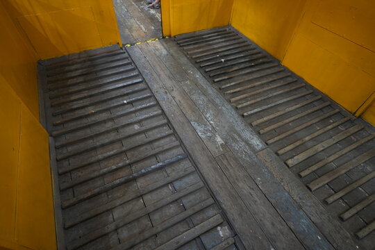 Interior of vintage yellow cargo train with wooden floor.