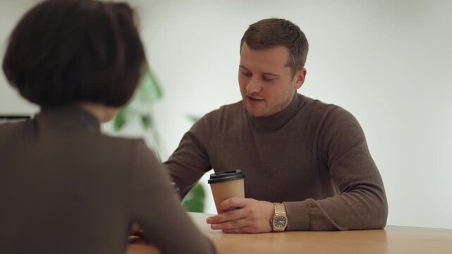 Young Professionals Having a Business Conversation Over Coffee in a Modern Office