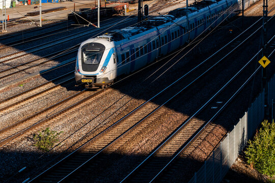 Urban transit and transport infrastructure in stockholm features commuter train on railway tracks suggesting speed movement and daily service