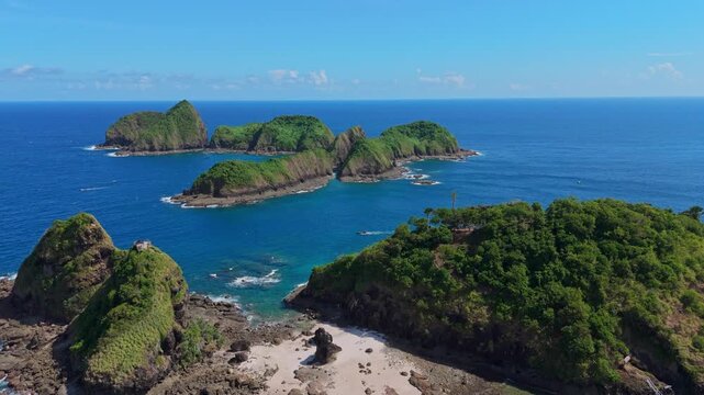 Aerial perspective of rocky tropical islands and a hidden sand beach in Banyuwangi, Indonesia