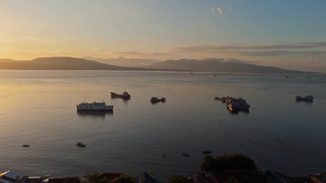 Aerial drone footage of peaceful morning at Ketapang harbor with misty mountains on horizon