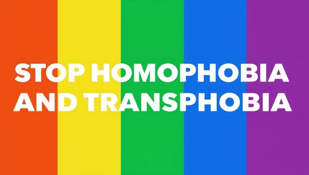 Stop homophobia and transphobia text over a colorful rainbow pride flag background representing equality and social justice for the lgbtq community