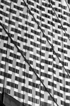 Contemporary monochrome building facade where modern abstract pattern waves and lines create bold texture and contrast in architectural design background