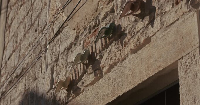 Decorative bird figures are mounted in a row on a stone wall above a doorway.