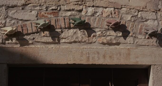 Decorative bird figures are mounted in a row on a stone wall above a doorway.