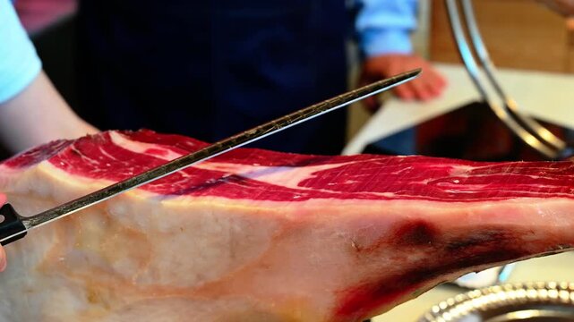 Chef cutting dry-cured spanish ham Jamon.
