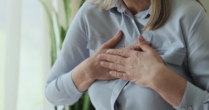 Close up old woman, chest inflammation and cardiovascular emergency in lounge, panic attack and physical symptoms.