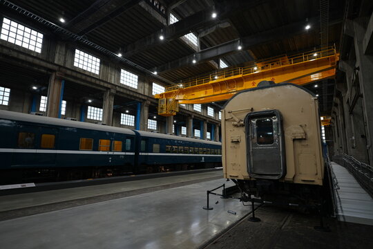 Vintage train carriages and overhead crane in a railway museum.