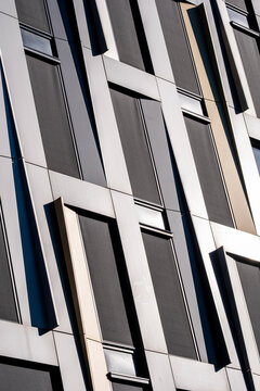 Angled lines lead across a modern building as architecture facade and windows form an abstract pattern with clean geometry and perspective