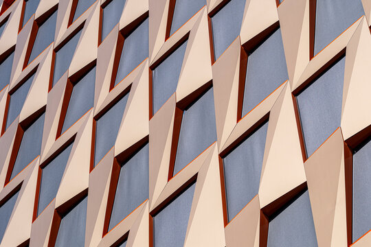 Color and repetition animate this architecture facade where modern panels and geometry create an abstract pattern with tactile texture