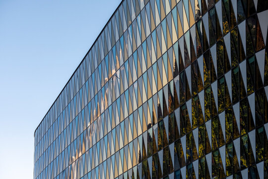 Geometric reflections across a modern building reveal architecture facade with glass windows in abstract pattern and sharp perspective detail