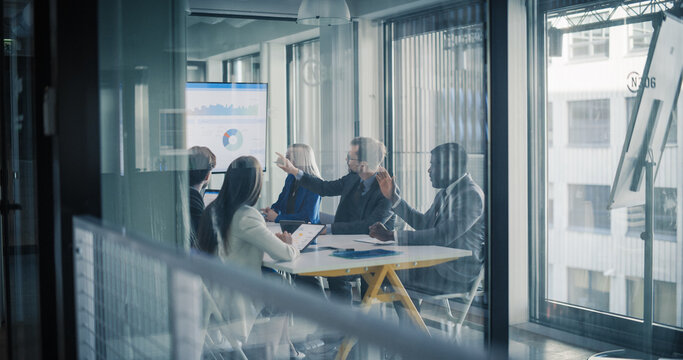 Business Team Meets in a Glass Conference Room to Review Dashboards, Explain Charts, Debate Priorities, and Agree on Clear Action Steps for Improving Sales Performance, Digital Marketing Campaigns