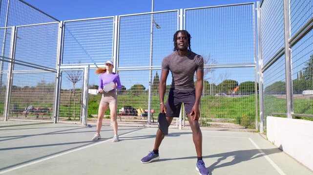 Diverse couple playing pickleball together on an outdoor court