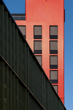 Red windows add contrast to modern minimal architecture facade with geometric lines detail creating bold contemporary background for posters