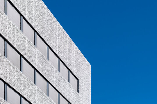 White windows in modern minimal architecture facade show geometric detail under blue sky delivering clean contemporary backdrop with copy space