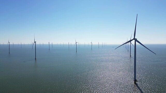 Green energy, wind turbines produce energy in the North Sea, wind farm power plant view from height, alternative energy sources.