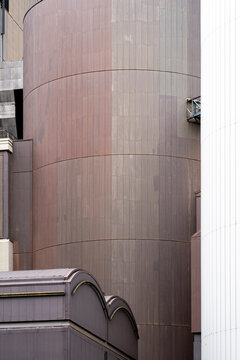 Brown tank industrial facade with curved metal skin and vertical texture detail forming a strong structure in an abstract exterior study