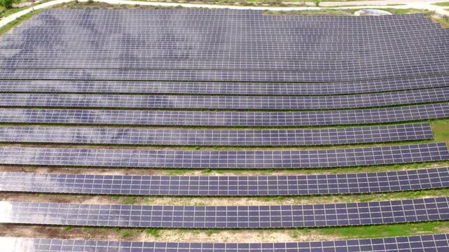Drone flying over a large solar panel farm for green energy production