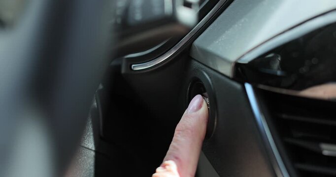 Elder woman presses engine start button in car. Close up woman hand, push start button in modern car.