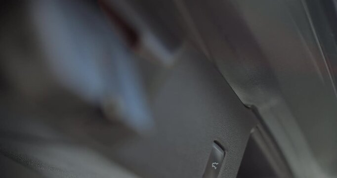 Close up woman hand presses car trunk close button and the trunk of the car is closed. Car trunk closing button.