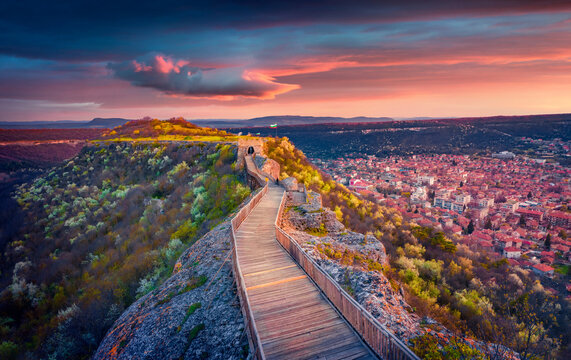 Majestic sunset on old fortress on the top of mountain. Colorful spring cityscape of Provadia town, located in a deep karst gorge along the Provadiya River, Bulgaria. Traveling concept background.