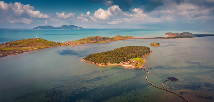 Panoramic summer view of St Mary's Monastery and wooden pier. Spectacular morning seascape of Narta Lagoon. Impressive outdoor scene of Albania, Europe. Beauty of nature concept background.
