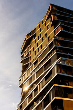 Sunlight hits a modern residential tower where architecture and balcony details define an urban Paris France corner with warm elegance