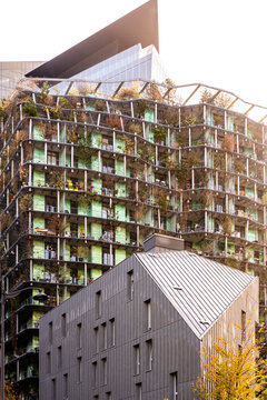 Modern residential tower architecture and facade wrapped in greenery above urban Paris France creating a distinctive exterior scene
