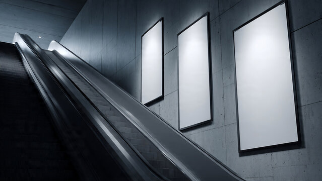 Industrial escalator ascending beside backlit blank concrete wall display panels, concept for transit advertising, mall