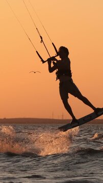 professional kitesurfer executing high jump trick sunset silhouette slow motion extreme water sports mastery