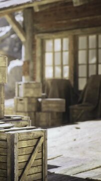 Snow blankets the ground as wooden crates are piled near a cozy cabin. The warm glow from the windows contrasts with the icy surroundings, creating a peaceful winter scene.