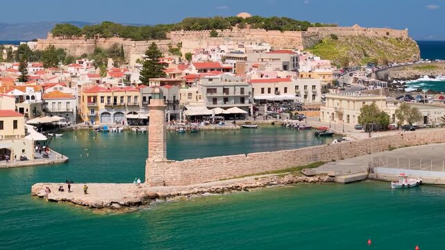 Greece Crete Rethymnon 4K 70mm Drone Video Close Up of Egyptian Lighthouse with People and Fortezza Castle Background Scenic Old Town and Mountains Panorama Travel