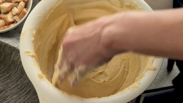 Kneading dough in a bowl for baking bread at home in the kitchen on a sunny afternoon