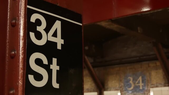 New York City Manhattan Midtown subway platform, 34 street metro near Herald Square and Penn Station, United States railway. Public metropolitan transport in USA, american railroad. Sign on column.