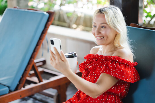 Happy Cheerful smiling Middle aged Caucasian woman using smartphone with positive smile expression for good news