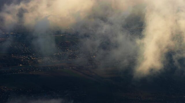 View from above Belgrade with clouds drifting over river, fields, and residential areas. Soft light and layered landscape create a calm, cinematic atmosphere over Serbia.
