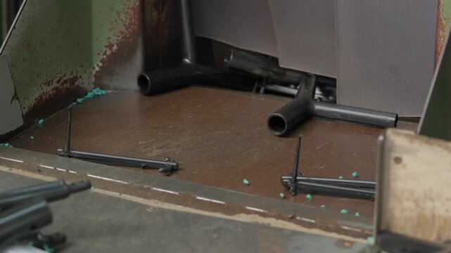 Black plastic chair frames and tubes feeding into heavy duty shredder machine on conveyor belt