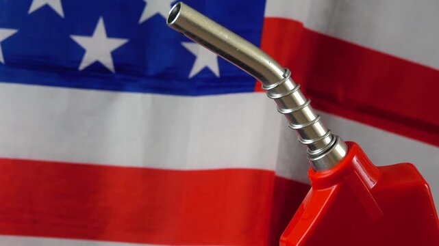 An evocative look at how the image of a fuel nozzle paired with the American flag represents the deep rooted reliance of the United States on oil
