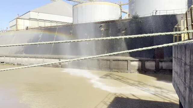 industrial waterfall, water spray from big high to the river. berth of the port protection from dust. 