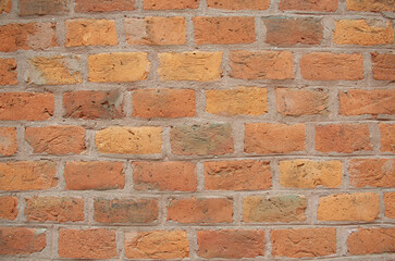 Fototapeta premium Closeup of an old red brick wall, rustic texture and weathered masonry pattern. Detailed architectural background, rough surface, vintage brickwork, and natural earthy colors. Copy Space wallpaper.
