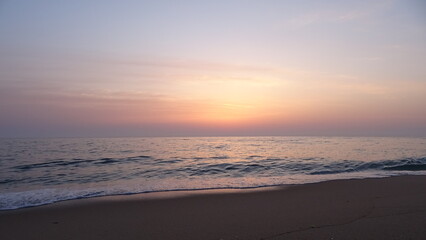 Obraz premium Stunning Purple and Orange Dawn Sky over East Sea. A beautiful color gradient of purple, pink, and orange in the sky as the sun begins to rise over the calm horizon of the East Sea.