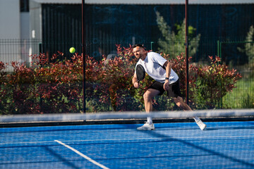 Naklejka premium Male padel player hitting ball during match