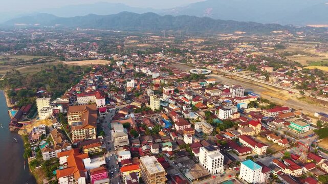 Aerial Drone Rotation Over Vang Vieng Town Surrounded by Mountains in Laos