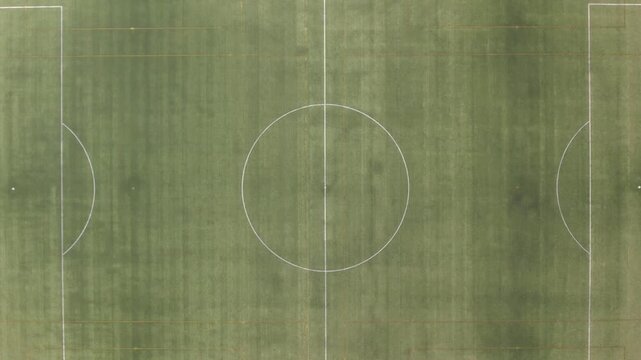 Aerial drone footage flying over two empty green soccer fields with white marking lines for sport competition and training
