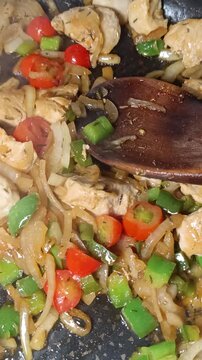 morceaux de poulet cuit avec oignons et poivrons dans une po&ecirc;le